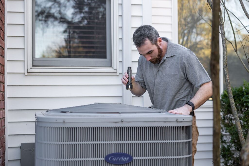 Technician inspecting an HVAC unit for maintenance